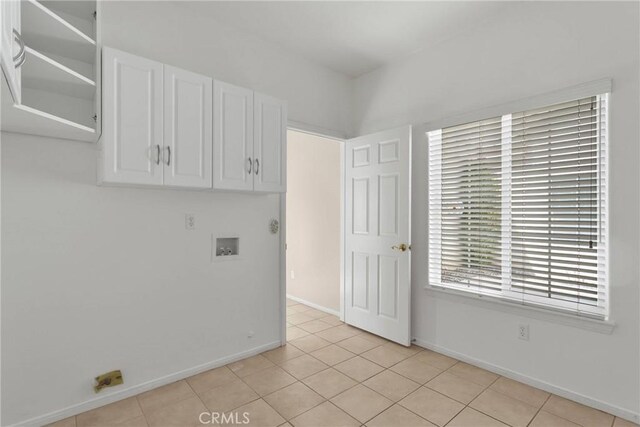 washroom with cabinets, light tile patterned flooring, and washer hookup