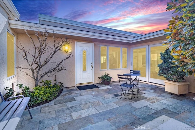 exterior entry at dusk featuring a patio area