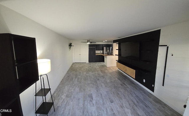 unfurnished living room featuring hardwood / wood-style floors and ceiling fan