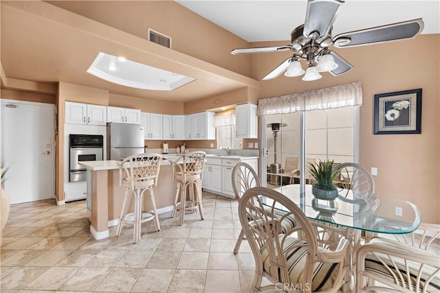 kitchen featuring a kitchen bar, sink, a center island, stainless steel appliances, and white cabinets