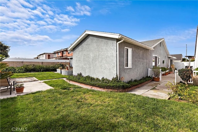 view of property exterior featuring a patio area and a lawn