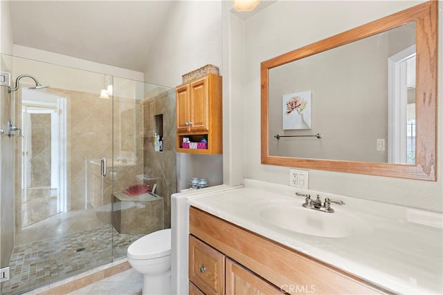 bathroom featuring a shower with door, vanity, tile patterned flooring, and toilet