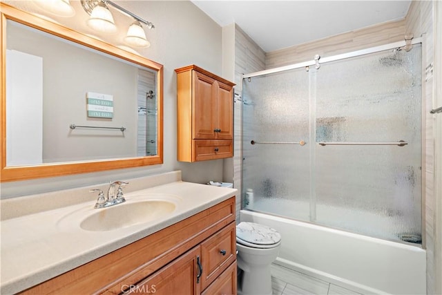 full bathroom featuring enclosed tub / shower combo, vanity, and toilet