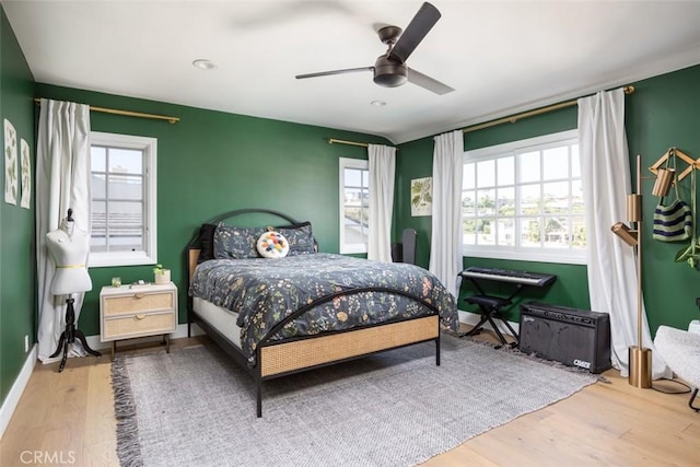 bedroom with ceiling fan, baseboards, and wood finished floors