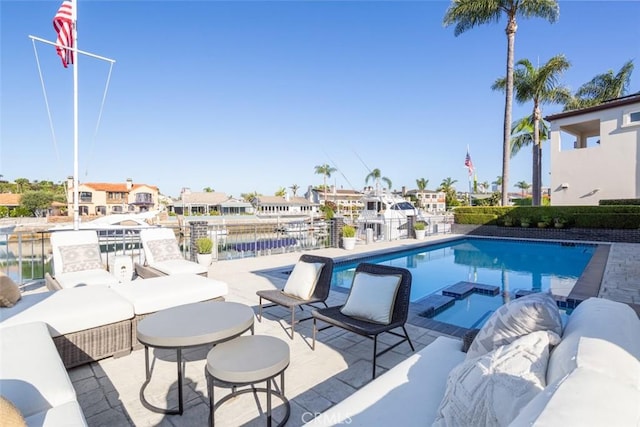 view of swimming pool with a pool with connected hot tub, a residential view, a patio, and a water view