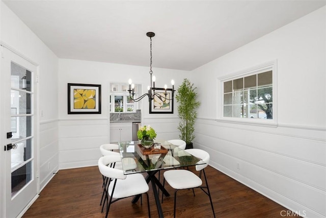 dining area featuring dark wood-type flooring, a wealth of natural light, and a notable chandelier