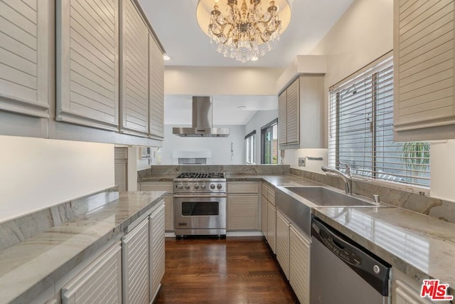 kitchen with sink, dark wood-type flooring, appliances with stainless steel finishes, extractor fan, and a notable chandelier