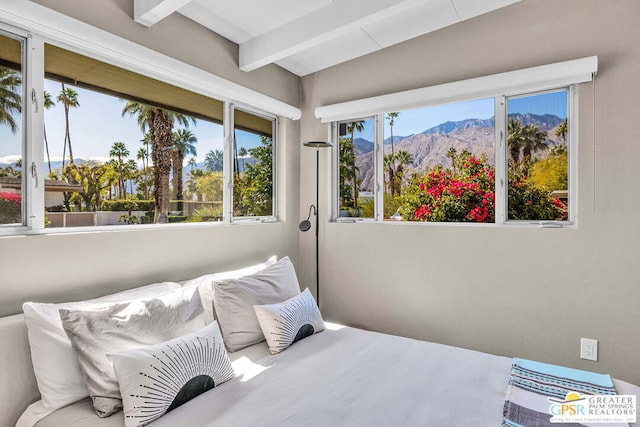 bedroom with a mountain view and beam ceiling