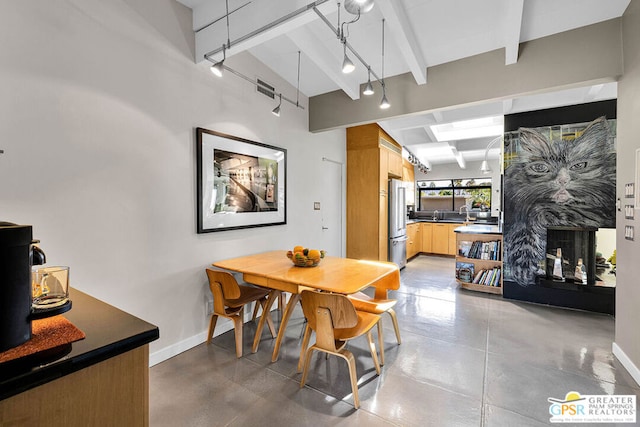 dining room with beam ceiling and concrete floors