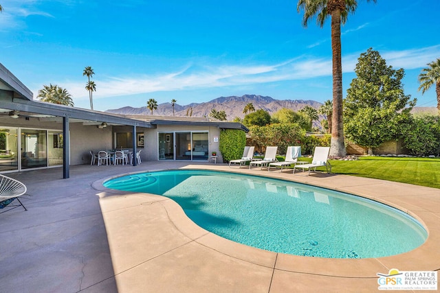 view of pool featuring a mountain view, a yard, and a patio area