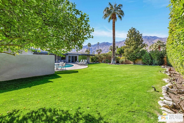 view of yard with a fenced in pool, a mountain view, and a patio area