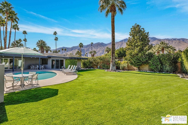 view of yard with a fenced in pool, a mountain view, and a patio