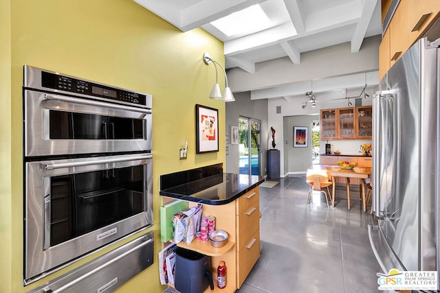 kitchen featuring decorative light fixtures, beamed ceiling, and appliances with stainless steel finishes