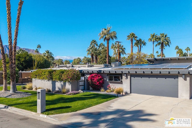 ranch-style house with a garage, a mountain view, and a front yard