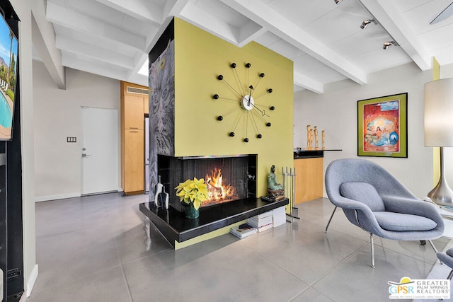 living room with lofted ceiling with beams and concrete floors