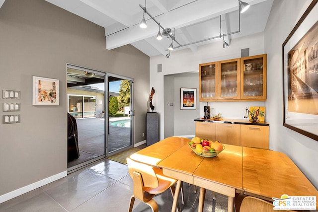 dining space featuring beam ceiling, concrete floors, and rail lighting