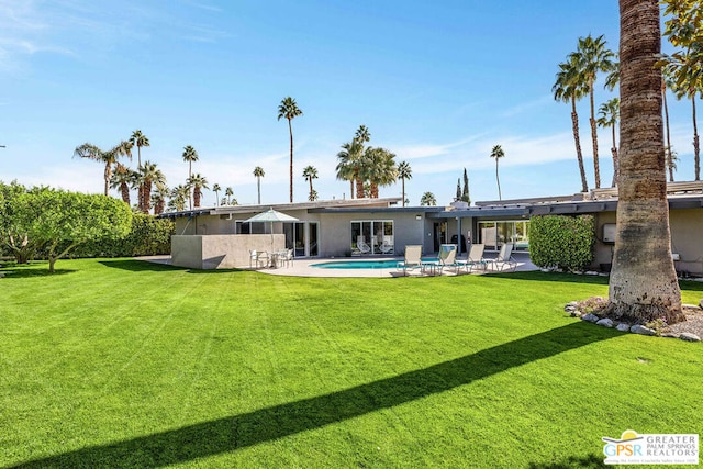 back of property featuring a yard and a patio