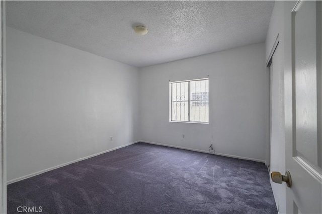 carpeted spare room with a textured ceiling