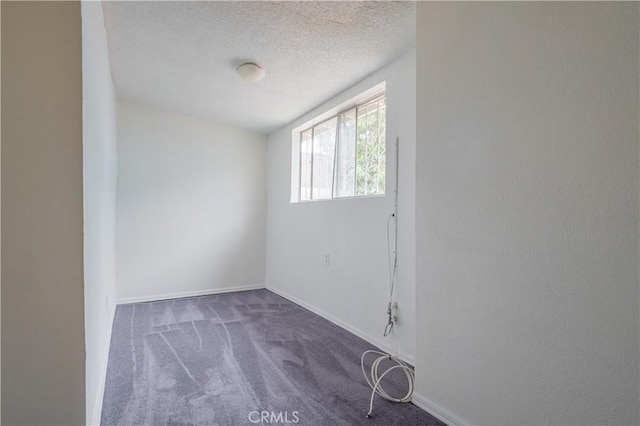 carpeted empty room featuring a textured ceiling