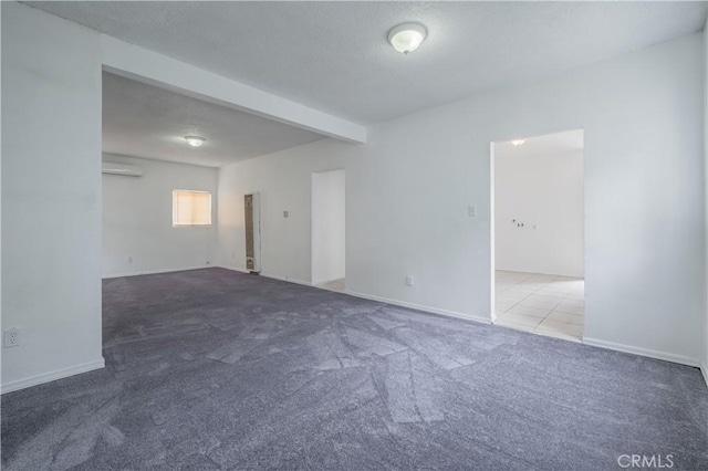 carpeted spare room with a wall mounted air conditioner and beam ceiling