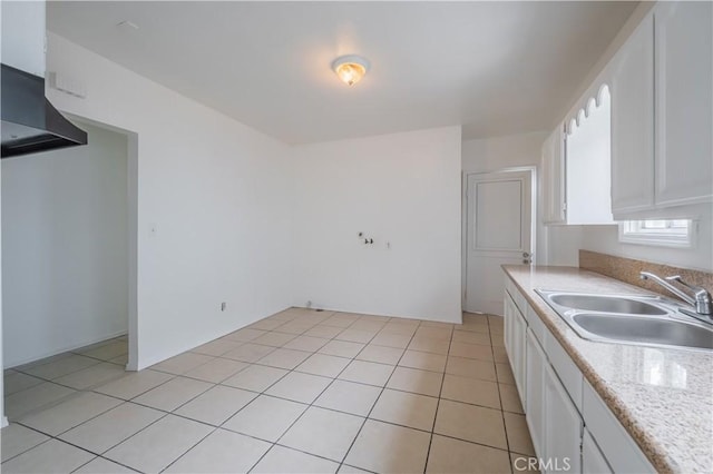 kitchen with white cabinetry, light tile patterned flooring, and sink