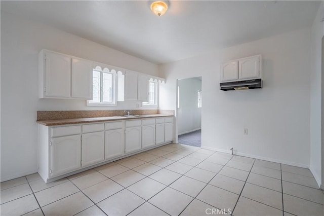 kitchen with white cabinetry, sink, and light tile patterned floors