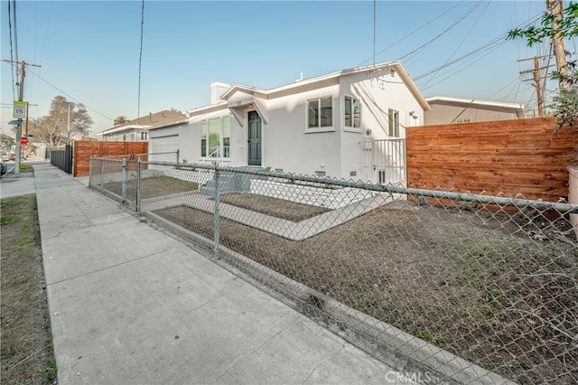 view of front of property featuring a fenced front yard, a gate, and stucco siding