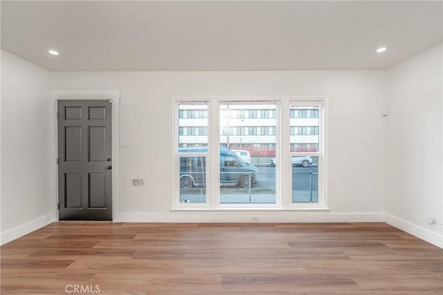 spare room with light wood-type flooring, baseboards, and recessed lighting