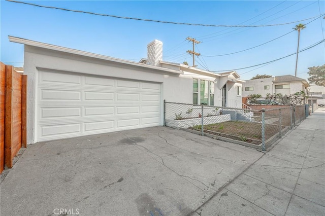 ranch-style home featuring an attached garage, fence private yard, driveway, and stucco siding