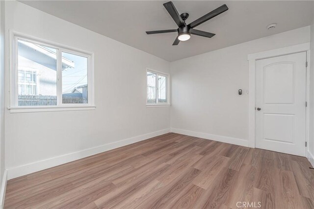 empty room with ceiling fan and light wood-type flooring