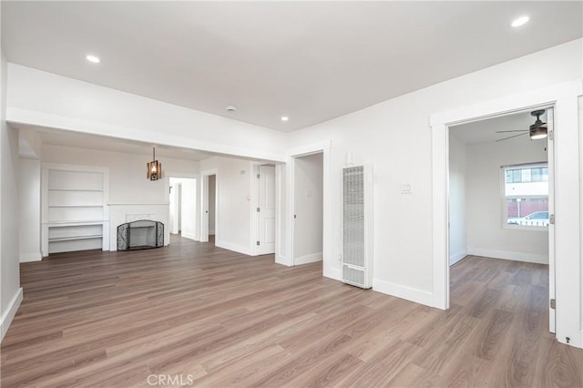 unfurnished living room with recessed lighting, a fireplace, visible vents, baseboards, and light wood finished floors