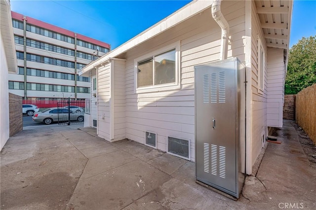 view of property exterior featuring fence and a patio