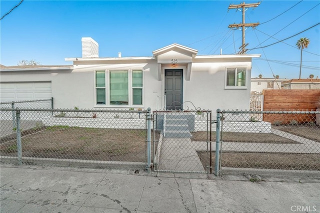 view of front of property with a fenced front yard, an attached garage, and stucco siding