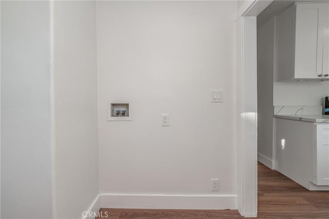 laundry room with baseboards, washer hookup, and wood finished floors