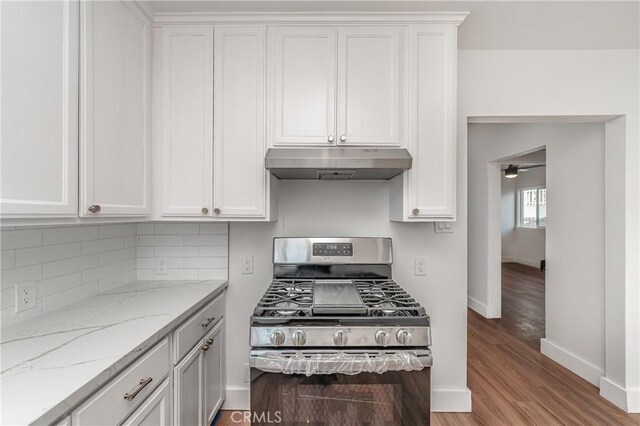 kitchen with stainless steel range with gas cooktop, white cabinets, and light stone counters