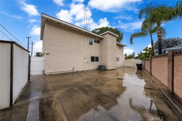 rear view of house featuring central AC and a patio area