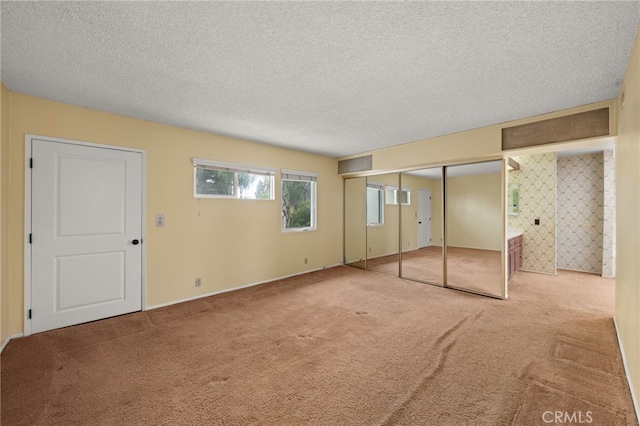 unfurnished bedroom with a textured ceiling and carpet