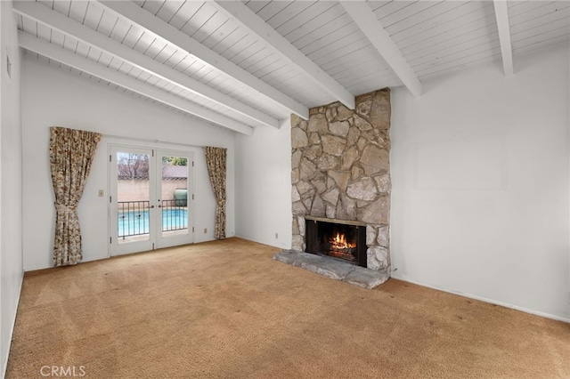 unfurnished living room featuring a stone fireplace, vaulted ceiling with beams, light colored carpet, and french doors