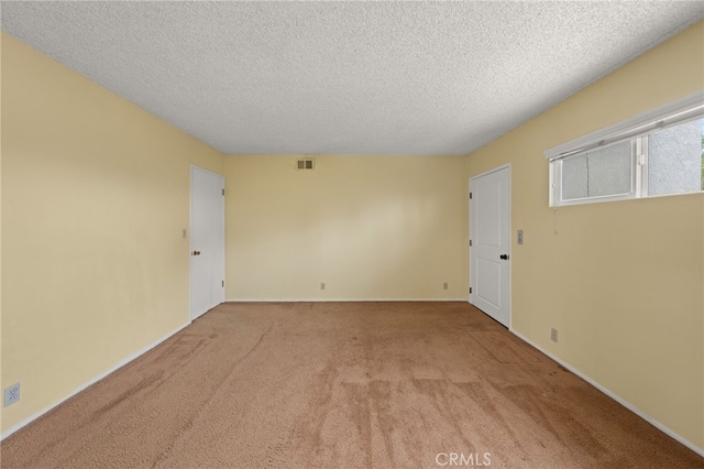 carpeted spare room with a textured ceiling