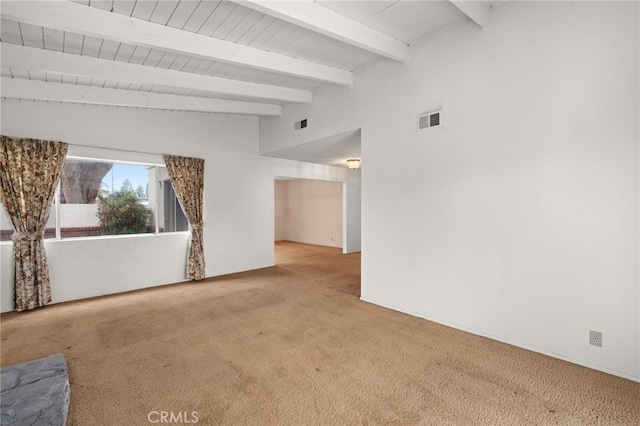 carpeted spare room featuring lofted ceiling with beams