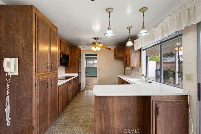 kitchen featuring kitchen peninsula, sink, hanging light fixtures, ceiling fan, and black appliances