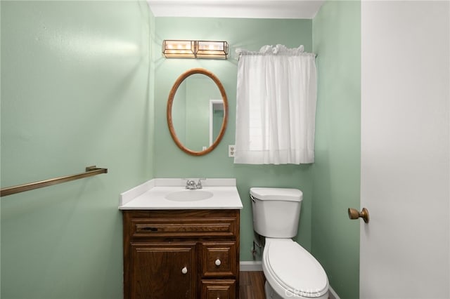 bathroom with vanity, toilet, and hardwood / wood-style floors