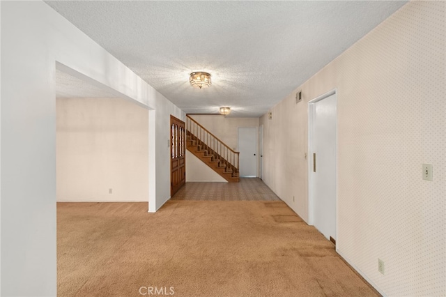 interior space with light colored carpet and a textured ceiling