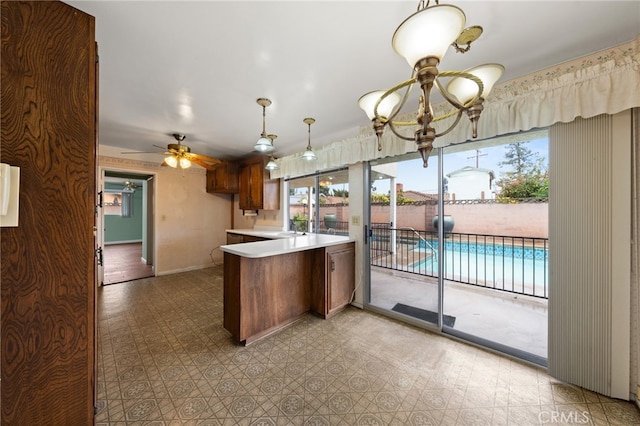 kitchen with ceiling fan with notable chandelier, pendant lighting, and kitchen peninsula