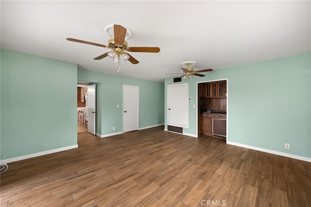 unfurnished bedroom featuring ensuite bathroom, dark hardwood / wood-style floors, and ceiling fan