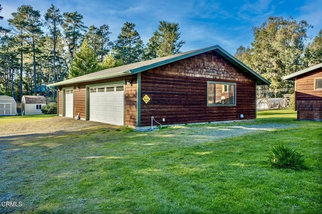 view of home's exterior featuring a garage, a lawn, and a shed