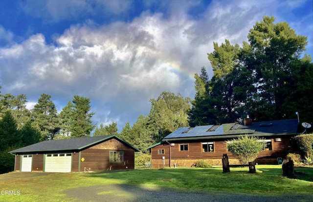 view of side of home featuring a garage, a yard, and solar panels