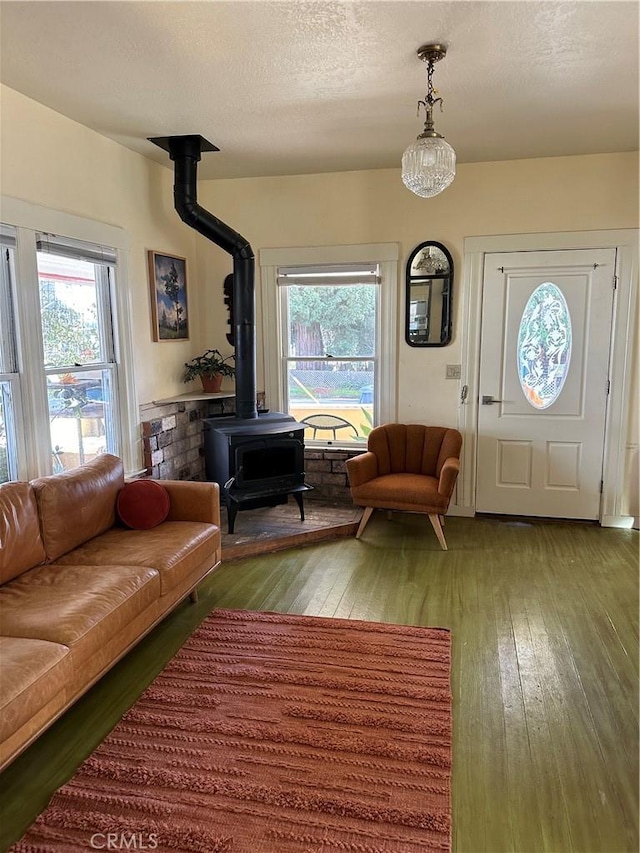 living room with hardwood / wood-style flooring, a textured ceiling, and a wood stove