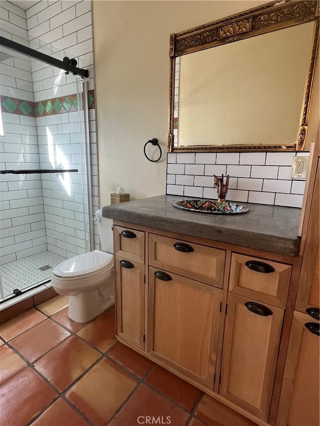 bathroom with tasteful backsplash, vanity, tile patterned floors, toilet, and walk in shower