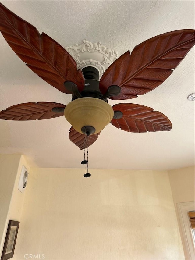 room details featuring a textured ceiling and ceiling fan